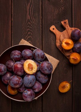 Mavi erik, ahşap bir masanın üstünde, üst manzara, yakın plan, insan yok.,