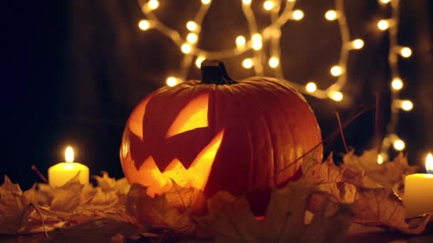 Jack O Linterna calabaza de Halloween con vela interior en hojas amarillas — Vídeo de stock