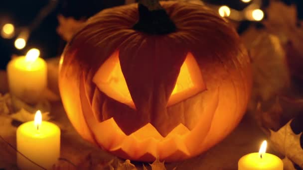 Jack O Lanterne Halloween Citrouille avec bougie à l'intérieur sur feuilles jaunes — Video
