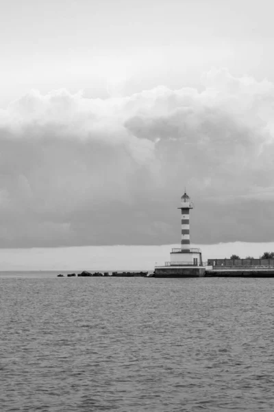 Limandaki kırmızı ve beyaz deniz feneri. Marine Pier 'da. Deniz Burnu, Odessa, Ukrayna. Siyah ve beyaz