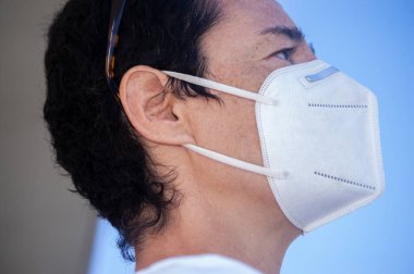 Kafkasyalı beyaz kadın portresi, kısa saçlı ön kabarıklığı korumak için maske takıyor.