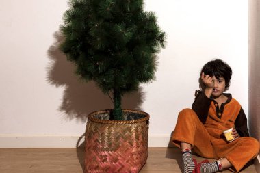 Bir çocuğun portresi otur ve Noel ağacını kur.
