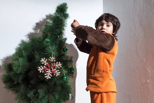 Retrato de uma menina colocando até decorações de árvore de Natal — Fotografia de Stock