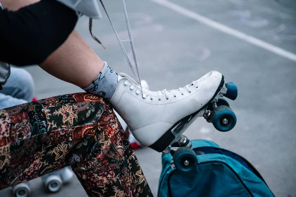 Young caucasian woman puts on white skates — Zdjęcie stockowe