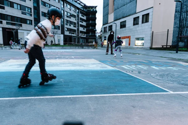 Beyaz çocuk şehir parkında paten çalışıyor.