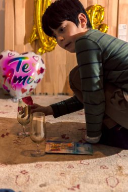 Bir beyaz çocuk sevgililer günü süslemeleri hazırlıyor.