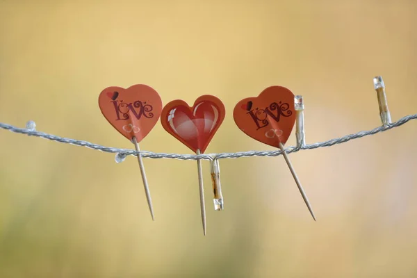 Valentýn ornament tři červená srdce s rozptýleným pozadím — Stock fotografie