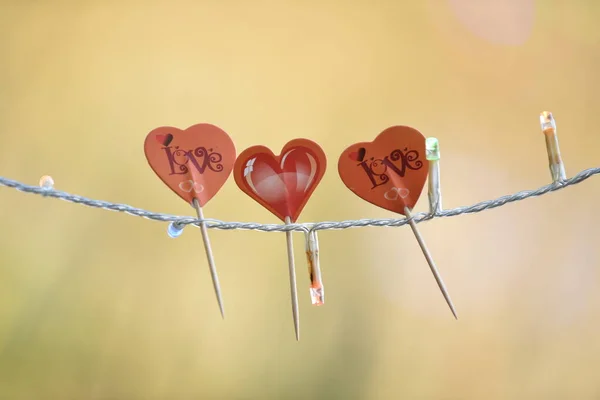Valentýn ornament tři červená srdce s rozptýleným pozadím — Stock fotografie