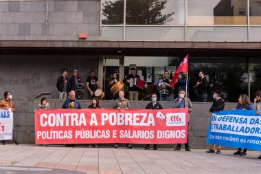 CANGAS, PONTEVEDRA, İSPA - 01 Mayıs 2022: Belediye binası önünde kırmızı pankartıyla işçi günü protestocuları
