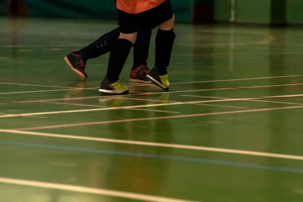 two children indoor football players run around the track