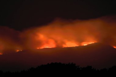 Illa de Arousa, Pontevedra, Spain. August 5, 2022: fire in Galicia the mountains burning in different spotlights tinged the night in Arosa Bay