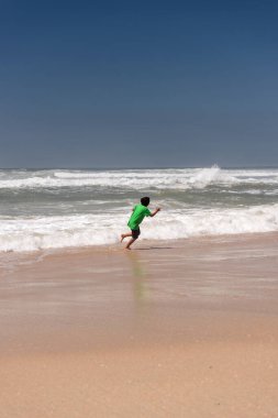 Bir kadın ve çocukları yazın Aveiro Portekiz sahilinde bir günün tadını çıkarırlar.