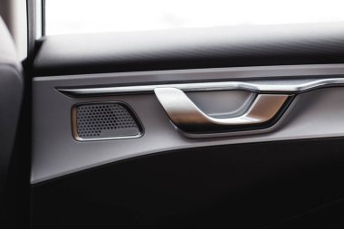 Kilit açma düğmeli iç kapı kolu, modern siyah araba iç mimarisi.