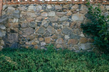 Küçük taşlarla birleştirilmiş büyük taştan yapılmış yüksek kale duvarı.