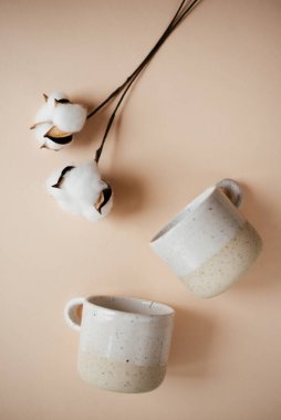 Şeftali arka planında 2 seramik bardak ve pamuk çiçeği, metin için yer 