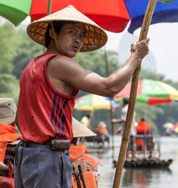 A Chinese man leads a bamboo boat in China — Stock Photo, Image