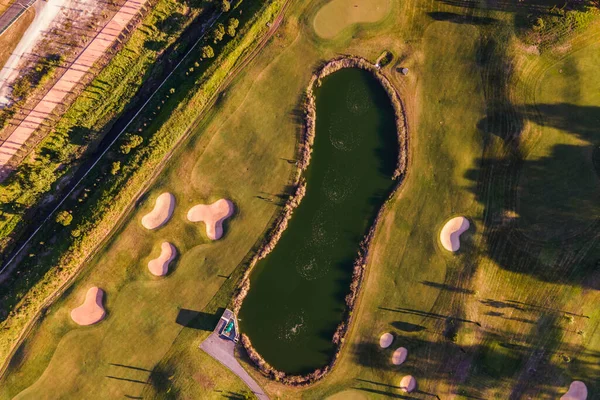 Aerial view of the golf court with a small lake in the field, view of the country sport club in Cruz Quebrada-Dafundo, Lisbon, Portugal.