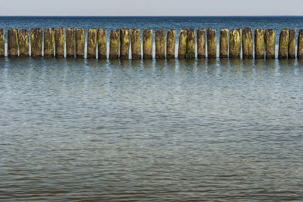 Veilige vakantie - houten palen op de oever — Stockfoto