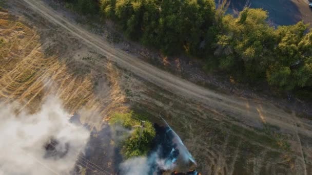 Bombero de visión aérea en trajes protectores resistentes al calor con manguera de incendio apagar llamas en campo agronómico — Vídeo de stock