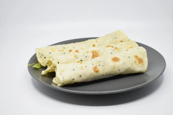  Gri tabakta peynirli ve yeşillikli Arap pidesi. Açık gri arkaplan.