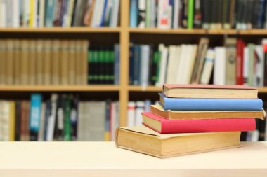 Kütüphanedeki masanın üzerinde kitap yığını