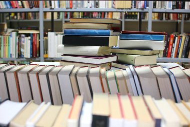 Kütüphanedeki masanın üzerinde kitap yığını