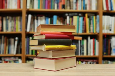 Kütüphanedeki masanın üzerinde kitap yığını