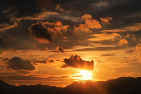 Mavi gökyüzü yağmur bulutlarının altında gün batımı
