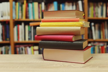 Kütüphanedeki masanın üzerinde kitap yığını