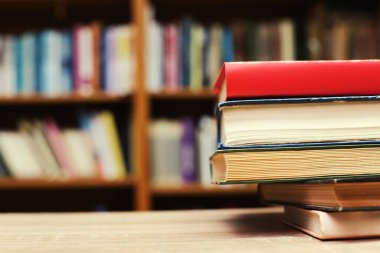 Kütüphanedeki masanın üzerinde kitap yığını