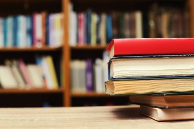Kütüphanedeki masanın üzerinde kitap yığını