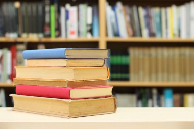 Kütüphanedeki masanın üzerinde kitap yığını