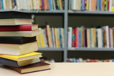 Kütüphanedeki masanın üzerinde kitap yığını