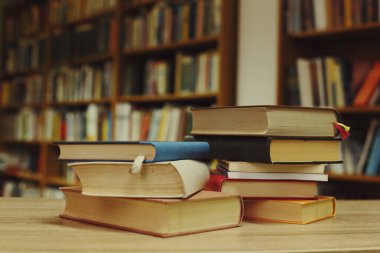 Kütüphanedeki masanın üzerinde kitap yığını