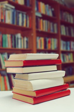 Kütüphanedeki masanın üzerinde kitap yığını