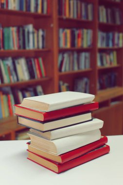 Kütüphanedeki masanın üzerinde kitap yığını