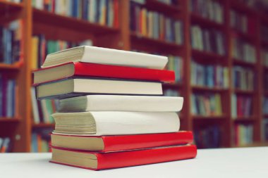 Kütüphanedeki masanın üzerinde kitap yığını