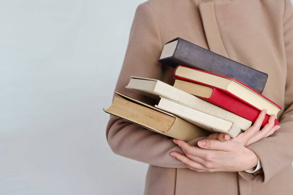 A young beautiful girl holding books in her hands