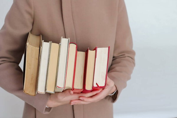 A young beautiful girl holding books in her hands