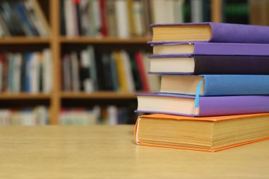 Kütüphanedeki masanın üzerinde kitap yığını