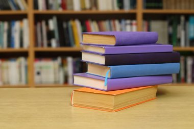 Kütüphanedeki masanın üzerinde kitap yığını