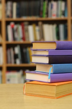 Kütüphanedeki masanın üzerinde kitap yığını