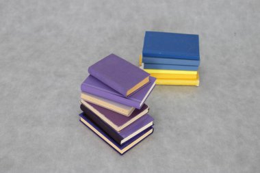 Gri arkaplanda mor kitap yığını