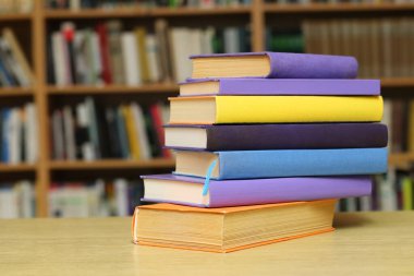 Kütüphanedeki masanın üzerinde kitap yığını