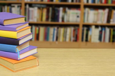 Kütüphanedeki masanın üzerinde kitap yığını