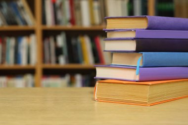 Kütüphanedeki masanın üzerinde kitap yığını