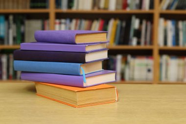 Kütüphanedeki masanın üzerinde kitap yığını