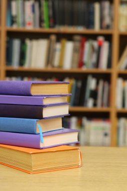 Kütüphanedeki masanın üzerinde kitap yığını