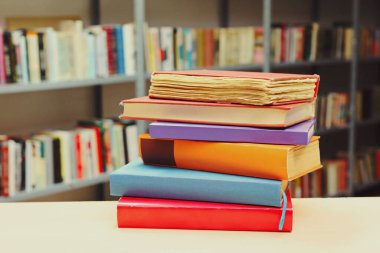 Kütüphanedeki masanın üzerinde kitap yığını
