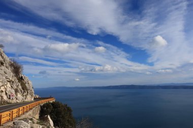 Mavi gökyüzü, denizin üstünde beyaz bulutlar